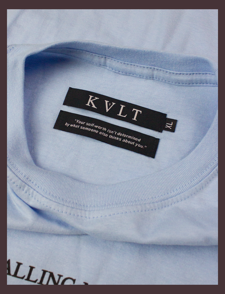 A close-up shot of the twin neck labels on the DON'T CALL ME Tee in Light Blue by KULT Clothing | The bottom label reads "Your self-worth isn't determined by what someone else thinks about you." | KULT