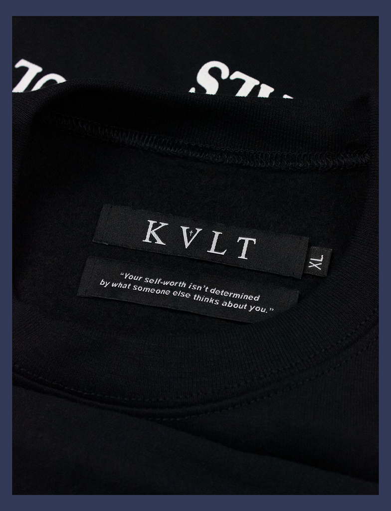 A shot of the self-worth twin labels inside the neckline of the MEANINGFUL GOALS Sweater by KULT Clothing | KVLT - "Your self-worth isn't determined by what someone else thinks about you."