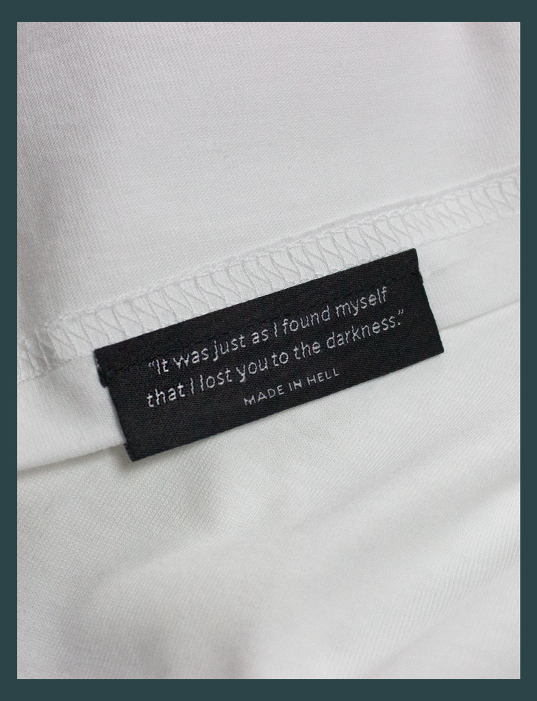 Close-up of the underside hem label on the CHANGE Tee by KULT Clothing | "It was just as I found myself that I lost you to the darkness." Made In Hell