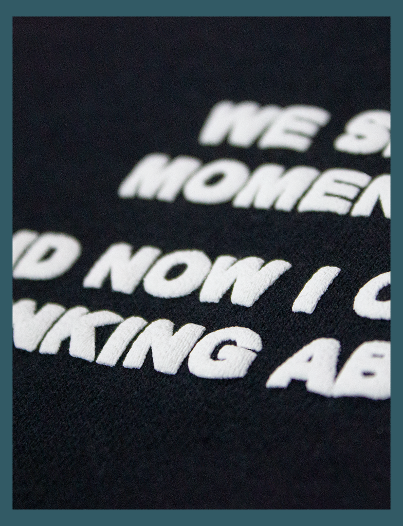 Extreme close-up of the puff screen print detailing on the breast print of the DISTANT LOVE Sweater in Black by KULT Clothing | We shared a moment once. And now I can't stop thinking about you.