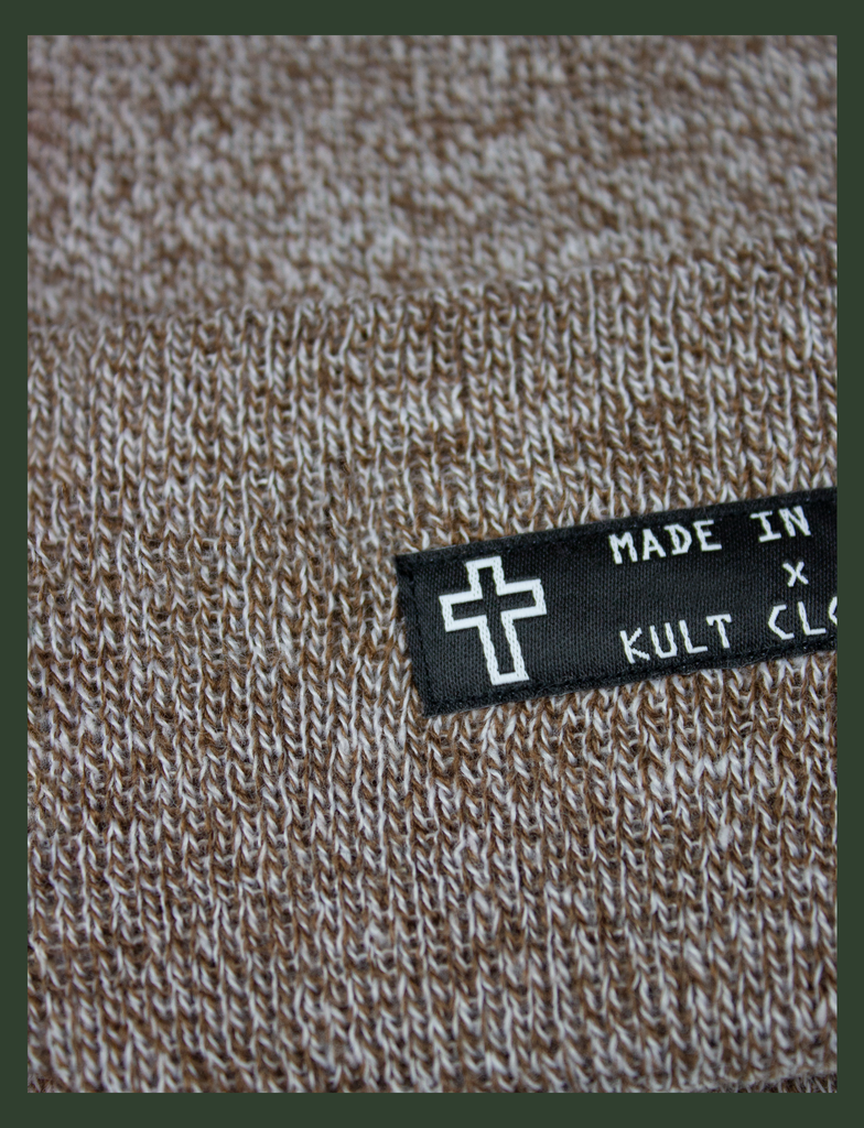 Close-up detail on the MADE IN HELL Beanie in Oatmeal by KULT Clothing | Black appliqué label on the front of a oatmeal-coloured, 100% acrylic knit beanie hat