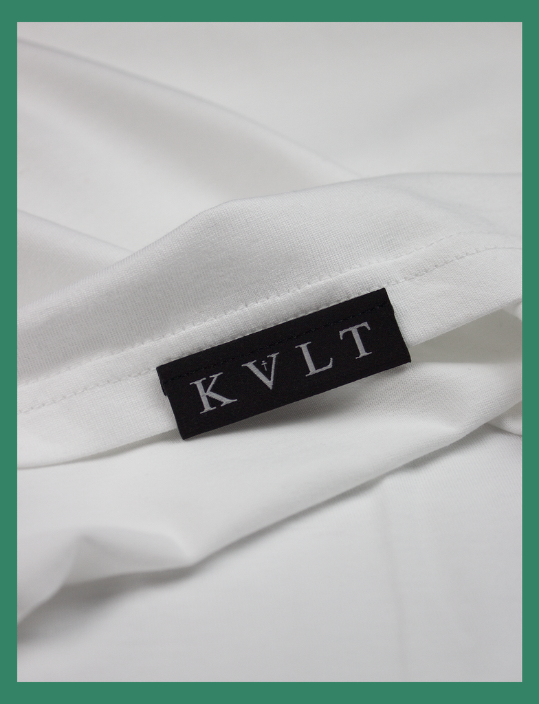 Close-up of the topside hem label on THE CALL Tee in White by KULT Clothing | eco-friendly, climate neutral t-shirt | Why am I only a slut when I'm not having sex with YOU?