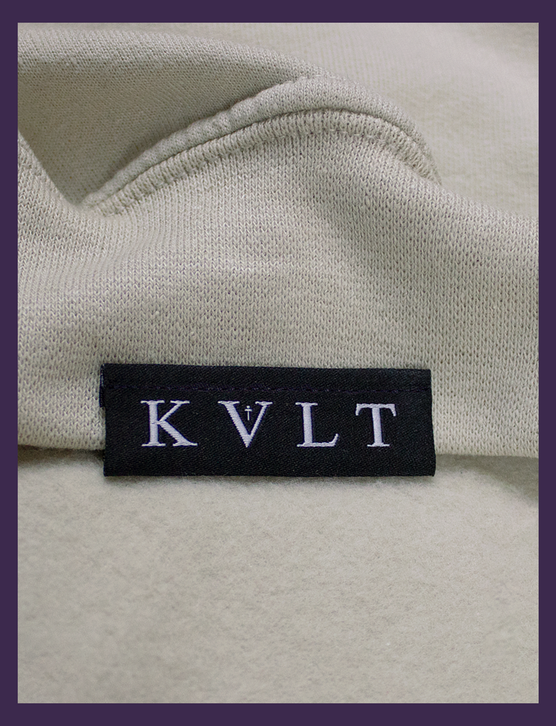 Close-up shot of the topside hem tag on THE JOY OF SATAN Sweater in Sandstone by KULT Clothing | The Joy of Satan | A Gourmet Guide to Sinning | KULT