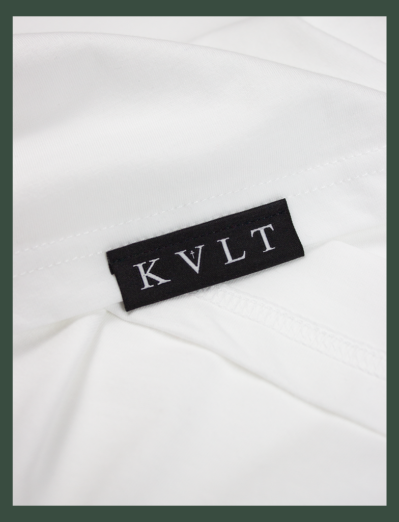 Close-up shot of the topside hem tag on the TIL DEATH Tee in White by KULT Clothing | eco-friendly, climate neutral t-shirt | 'til death, we do art. | till death we do art