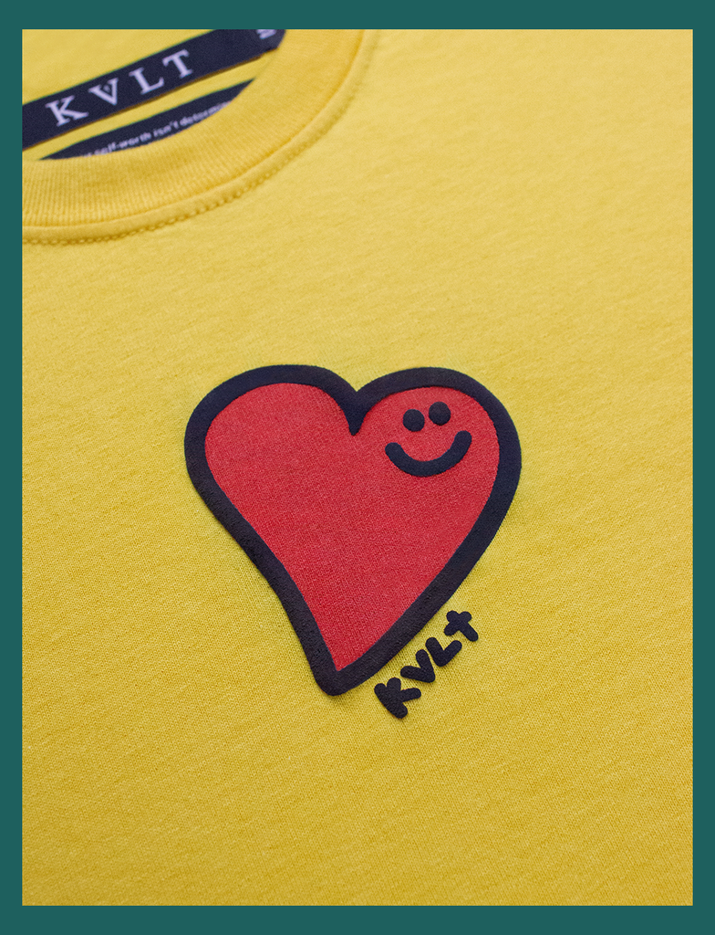 Close-up view of the hand-printed design in the centre of the chest on the GOOD DAY Tee by KULT Clothing | The design features a smiling heart with a puff effect | Hand-printed using eco friendly inks