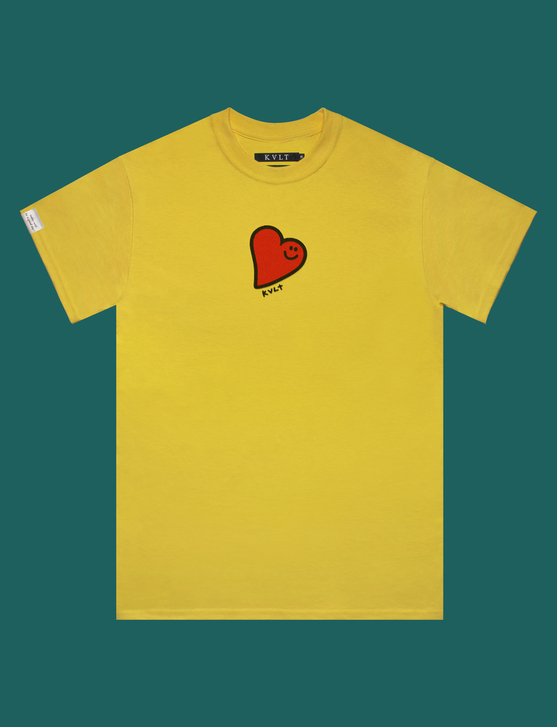 Front view of the GOOD DAY Tee in Sunflower by KULT Clothing | The print is of a goofy-looking smiling heart made using puff ink on a bright yellow t-shirt
