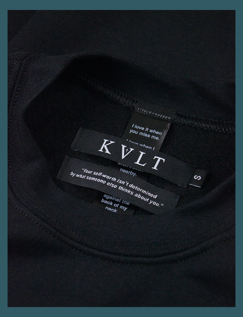 Close-up shot of the self-worth dual neck labels on the DISTANT LOVE Sweater in Black by KULT Clothing | "Your self-worth isn't determined by what someone else thinks about you." | KVLT