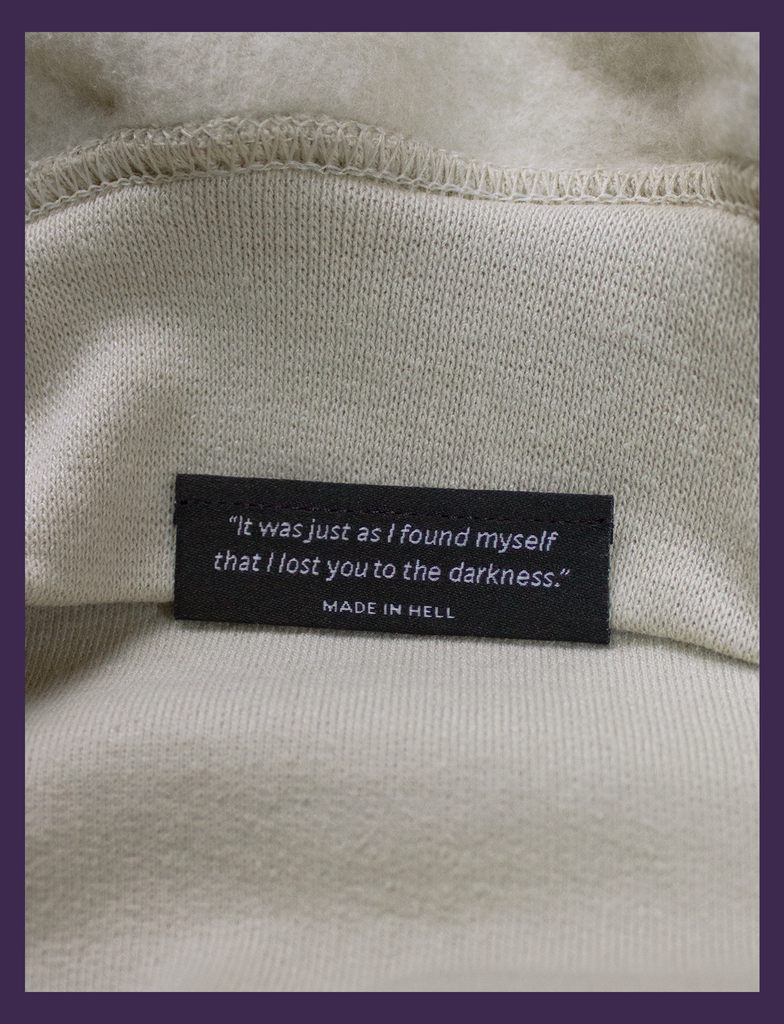 Close-up shot of the underside hem tag on THE JOY OF SATAN Sweater in Sandstone by KULT Clothing | The Joy of Satan | "It was just as I found myself that I lost you to the darkness."  | KULT